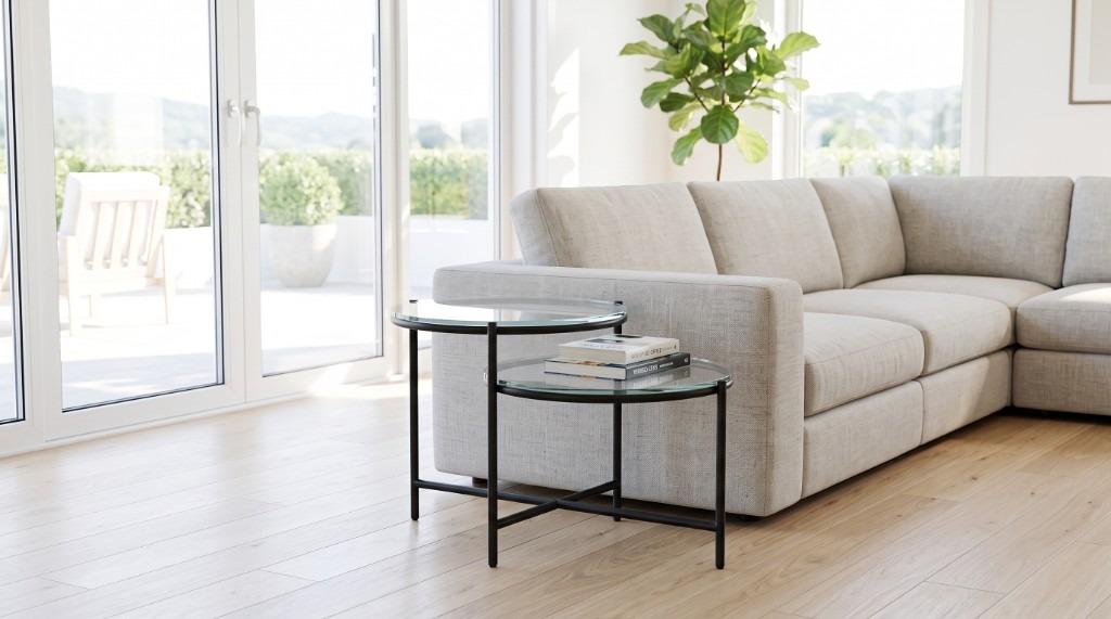 Twain nesting end tables with glass tops and black metal frames in a modern living room